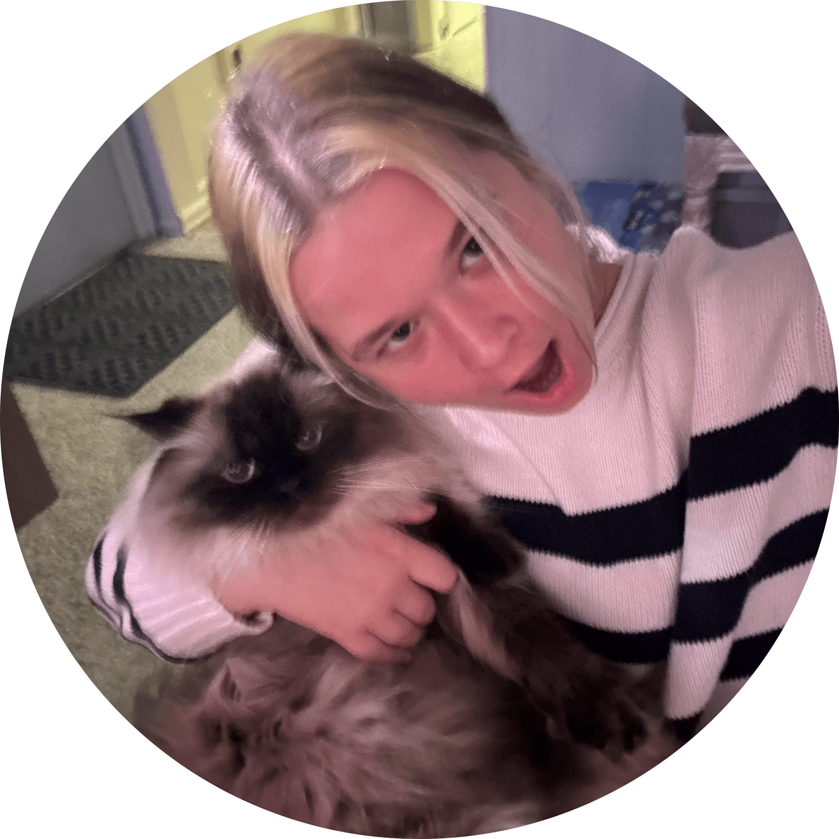 Evelyn Koop in a black and white striped sweater with pale skin, blonde hair, and brown eyes with her fluffy black and white cat